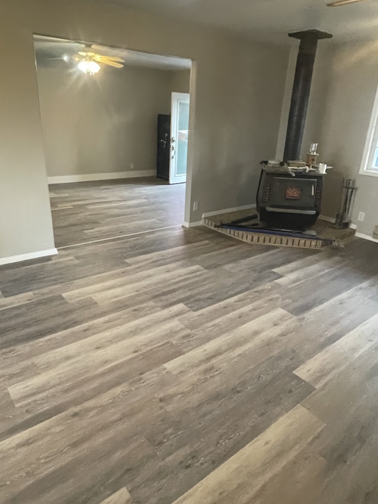 Open living room with new hardwood floors and wood stove
